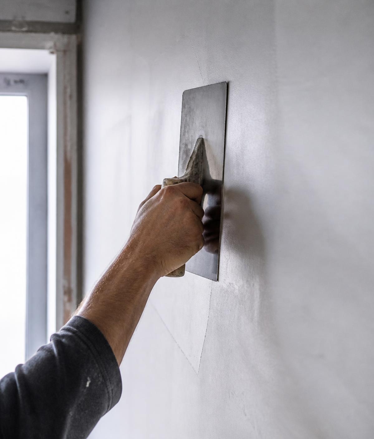 Muur wordt glad afgewerkt met een pleisterspaan